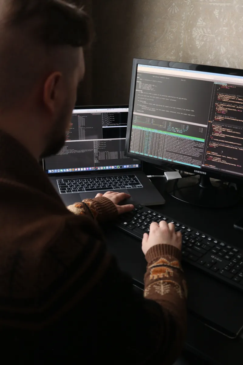 Developer writing code on a dual-monitor workstation